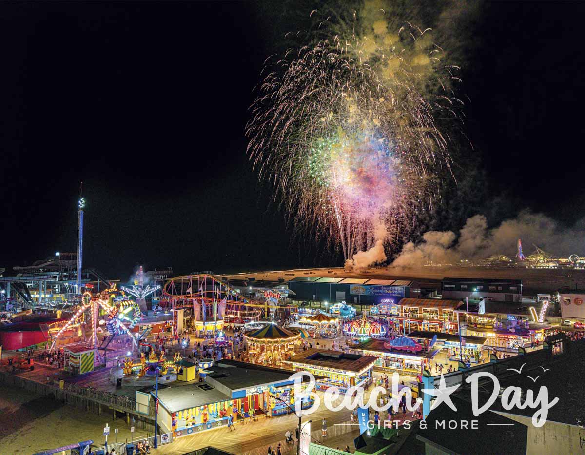 Fireworks over the Wildwood boardwalk amusement rides at night
